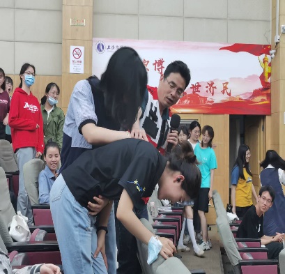 图为梁斌老师在指导学生关于海姆利克氏急救法的做法